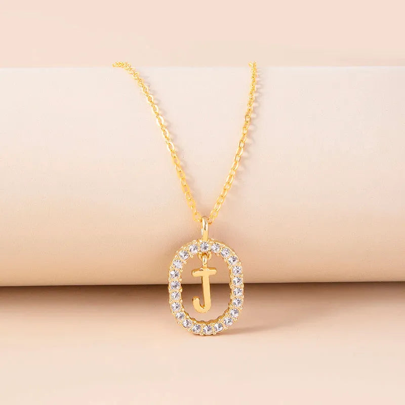 Gold crystal letter necklace with rhinestone initial on oval pendant and O-chain