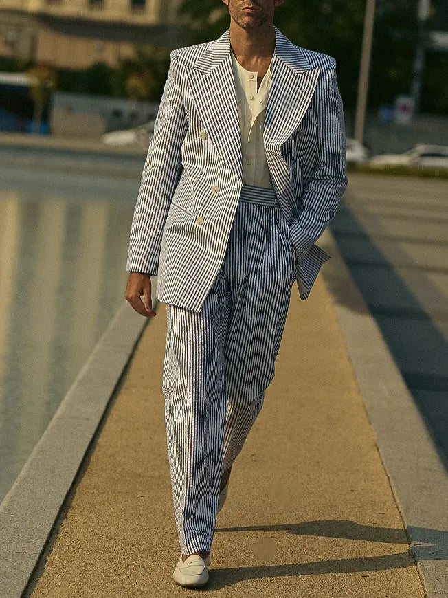 Blue and white striped men's polyester suit set with blazer and trousers on a model.