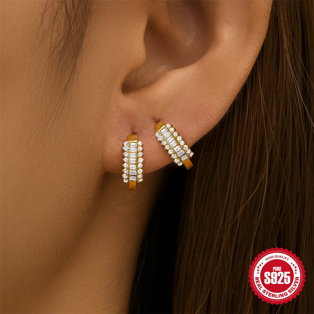 A pair of sterling silver geometric stud earrings with small round accents, shown in gold plating.