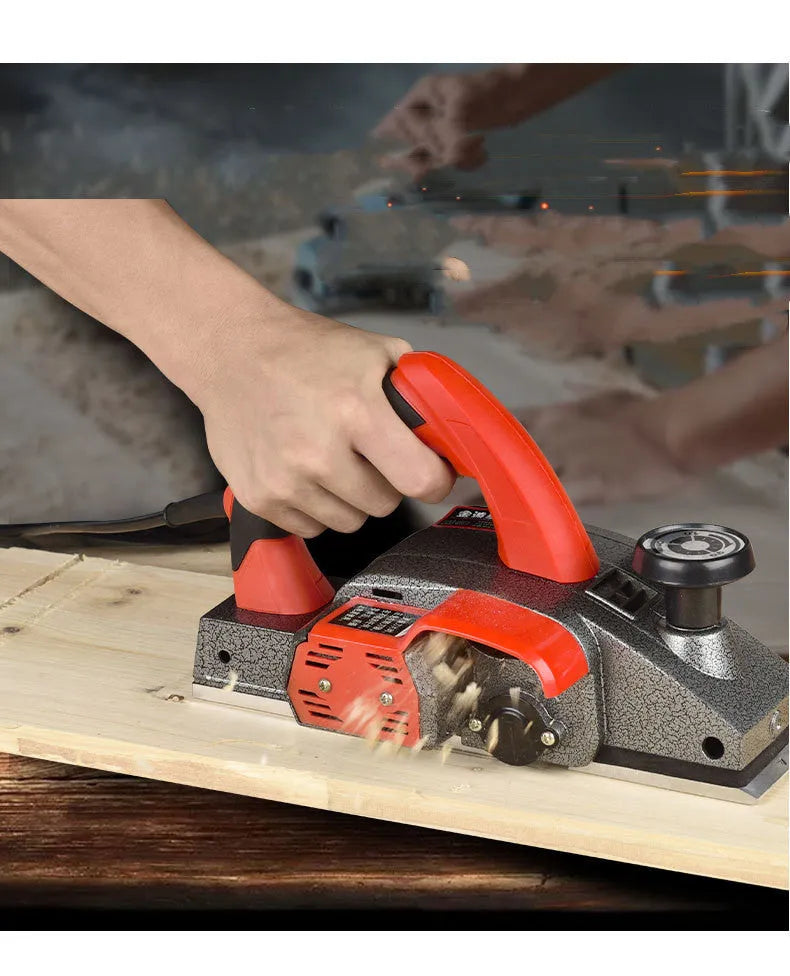 Red aluminium-shell electric wood planer with 82mm planing width and 1400W motor for carpentry tasks.