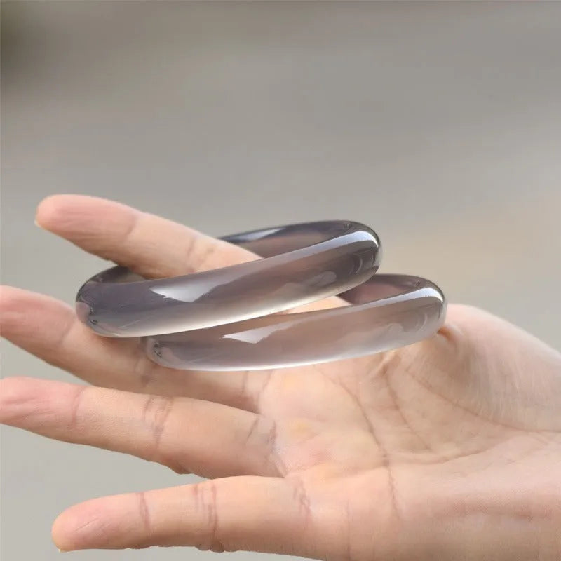 Dark grey Brazilian iced chalcedony agate bracelet with natural pattern, shown on a wrist.