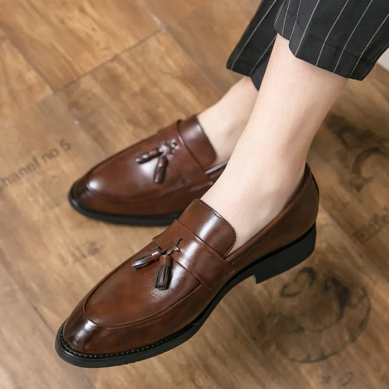 Men's black slip-on loafers with a tassel decoration on a pointed-toe, low-top artificial PU upper.