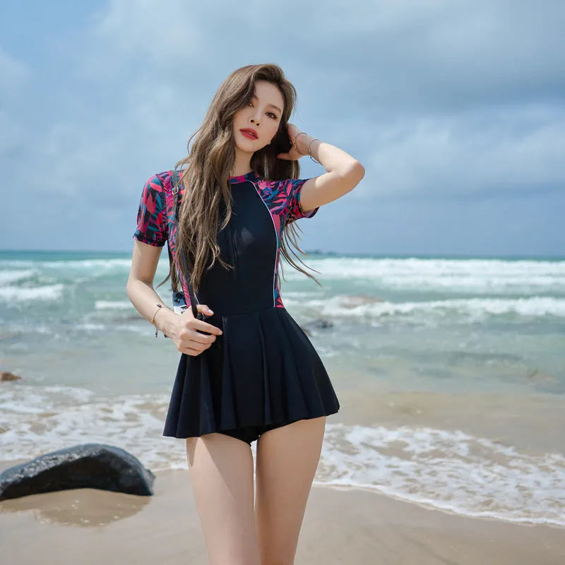Women's black flower pattern one-piece swimsuit with long sleeves and a tight, dress-style fit.