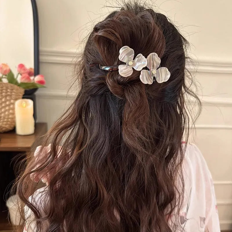 Close-up of a retro-style floral bobby pin hair clip with acrylic petals in a choice of colours.