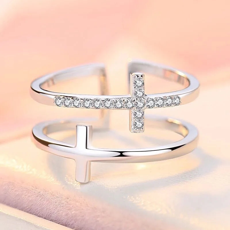 Close-up of a women's adjustable copper ring featuring a miniature double cross design with a zircon stone set in sterling silver.