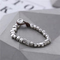 Handmade silver bracelet with irregular square design and wooden elements on 17cm elastic band