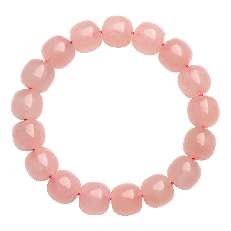 Pink natural crystal bracelet with barrel-shaped beads on a wrist.