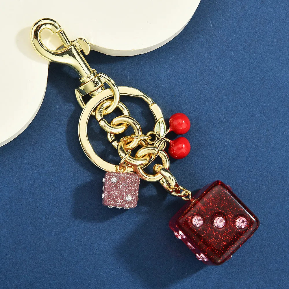 Square cherry red and silver dice pattern metal keychain pendant on a key ring