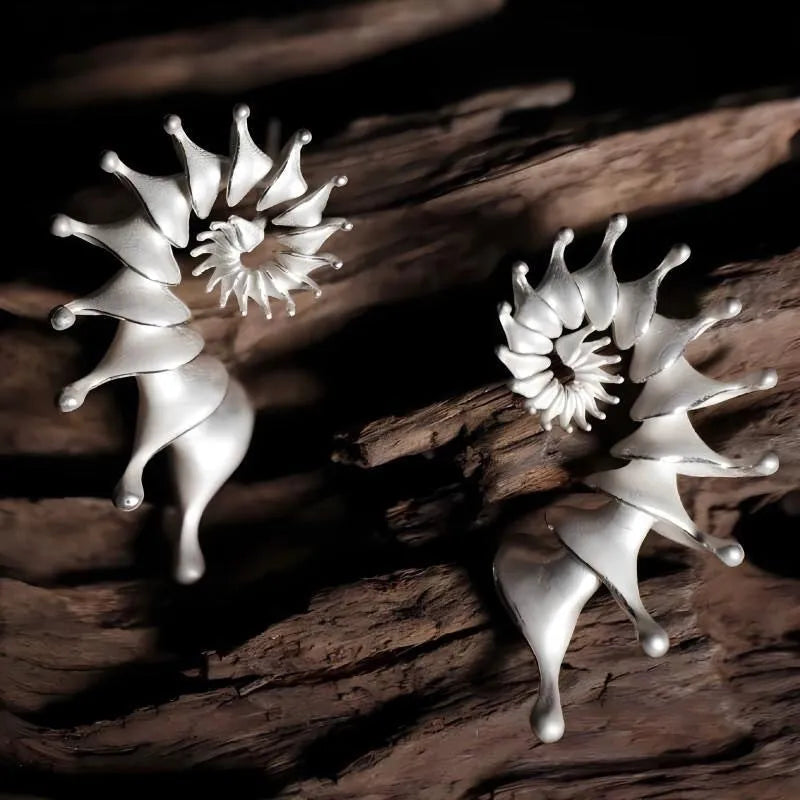 A pair of alloy conch-coloured stud earrings with an irregular three-dimensional shape and a matte finish.
