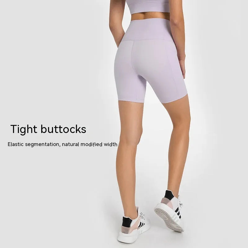Women's solid colour mid-length sports shorts with a tight fit and waistband.