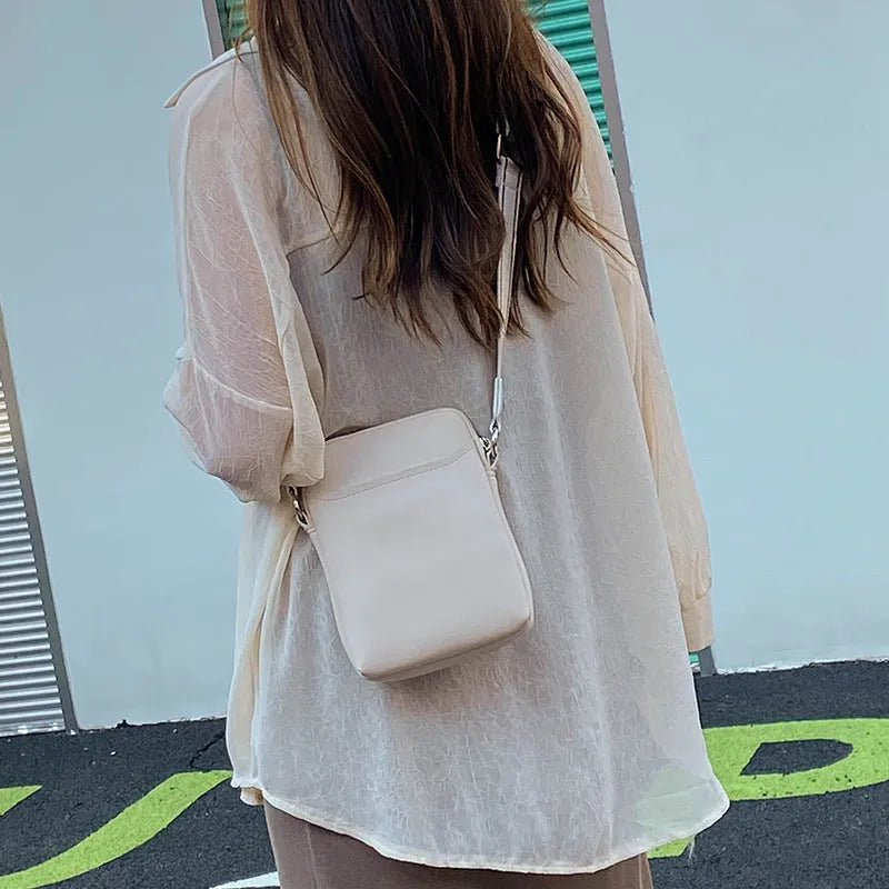Solid colour PU leather crossbody shoulder bag for women with adjustable strap.