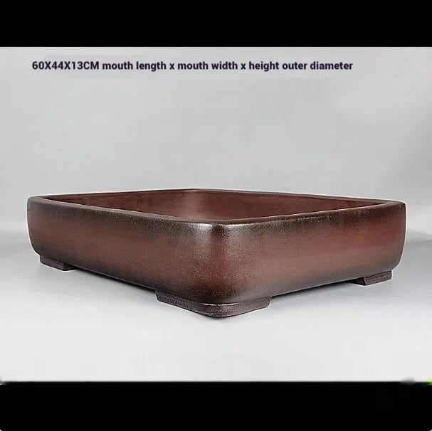 Handmade large rectangular purple clay flower pot for floor plants on a table.
