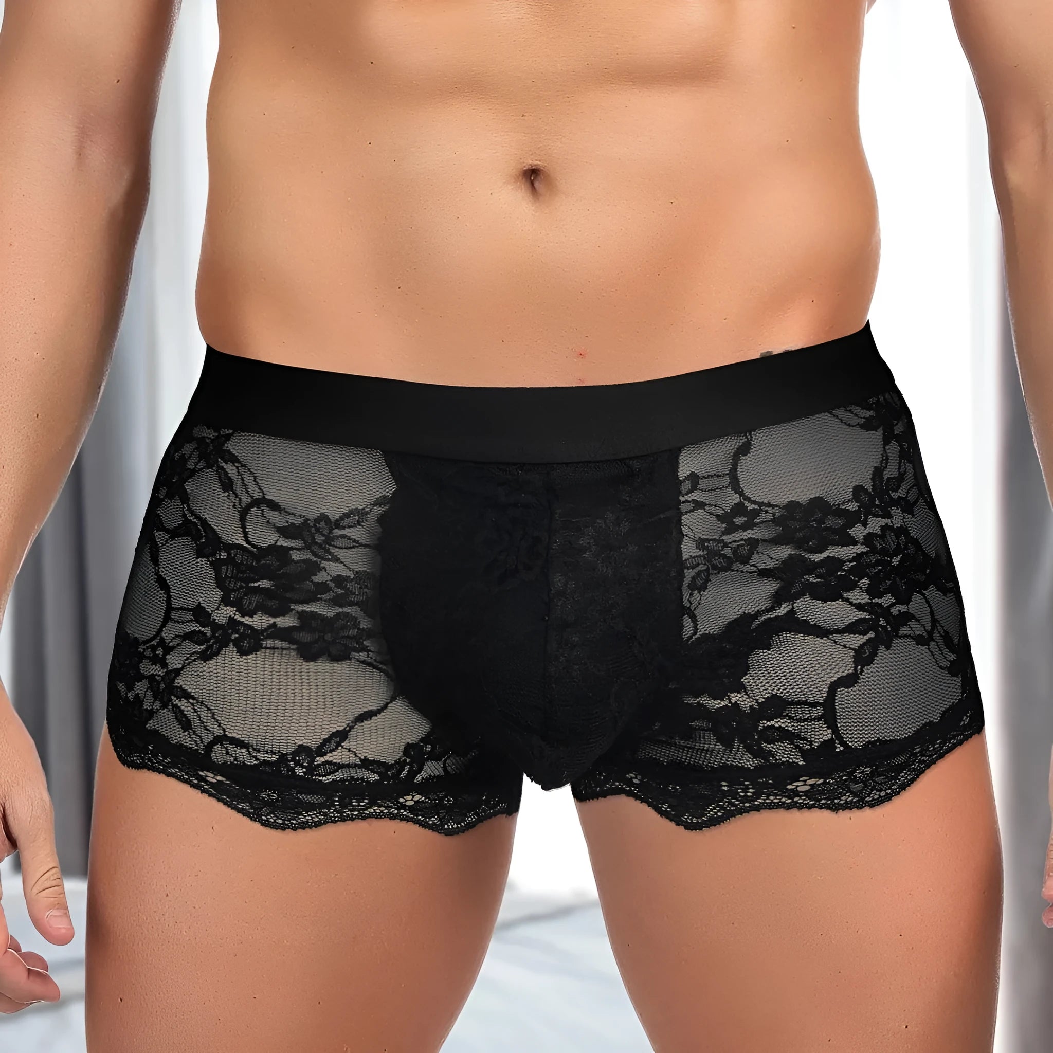 Men's black lace briefs with a hollow-out, see-through design on a neutral background.