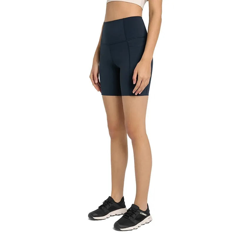 Women's solid colour mid-length sports shorts with a tight fit and waistband.