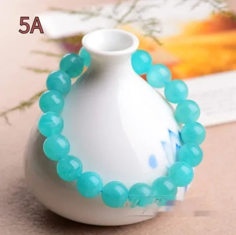 Loose natural blue-green Amazonite beads in various sizes from 6mm to 13mm on a white surface.