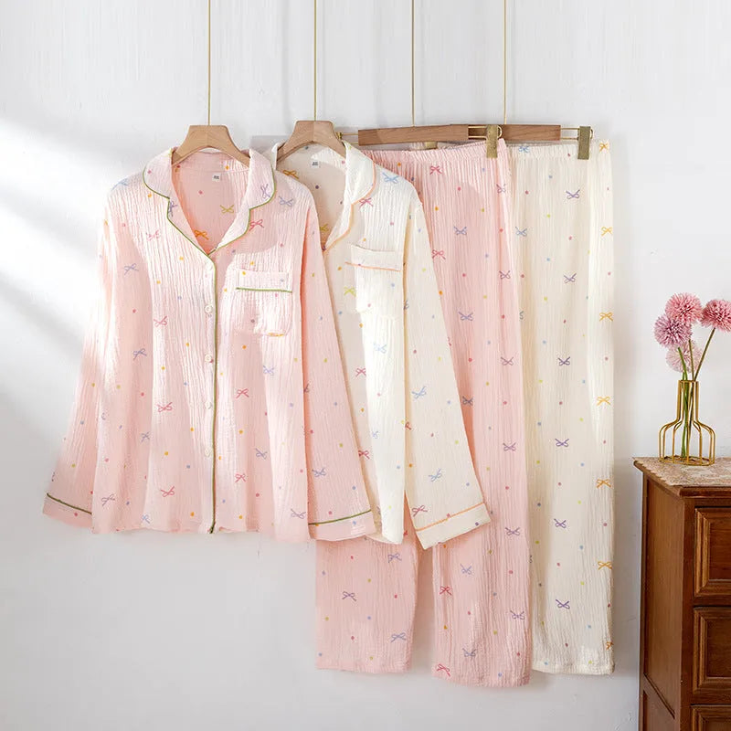 Women's beige thin cotton long sleeve pajama top and trousers set laid flat.