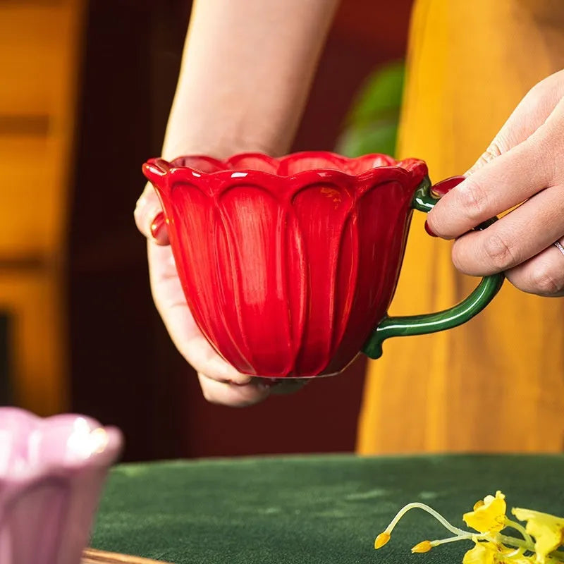 A red and purple floral ceramic cup with a 500ml capacity on a wooden table.