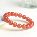 Natural cherry red agate beaded bracelet showing polished stones on a wrist, demonstrating single and triple strand options.