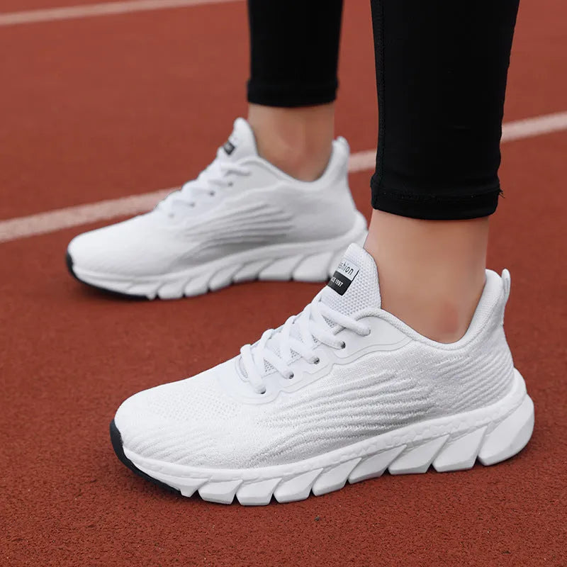 Low-top black and white running sneakers with cross-strap detail and flat MD sole.