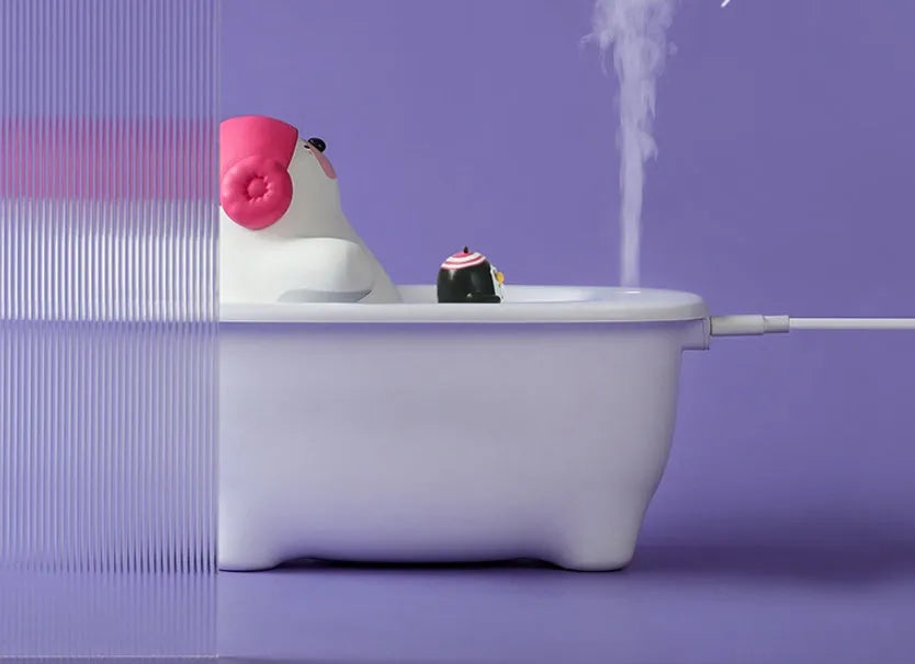 White compact USB air humidifier with large water tank on a desktop.