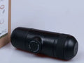 Black portable manual coffee machine measuring 6cm by 17.5cm on a table