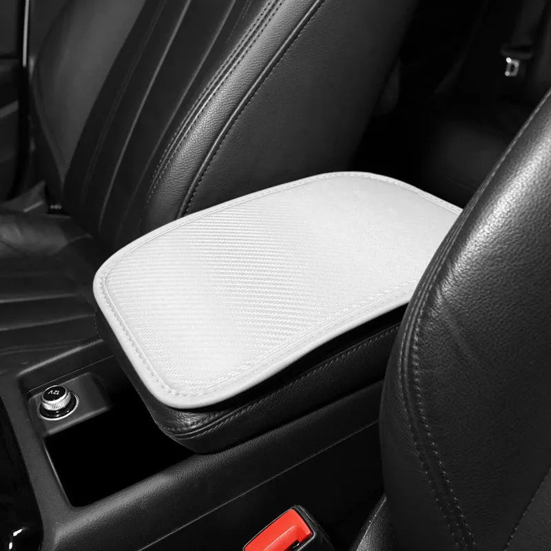 Leather car armrest cushion with carbon fibre pattern in red, shown on a car centre console.