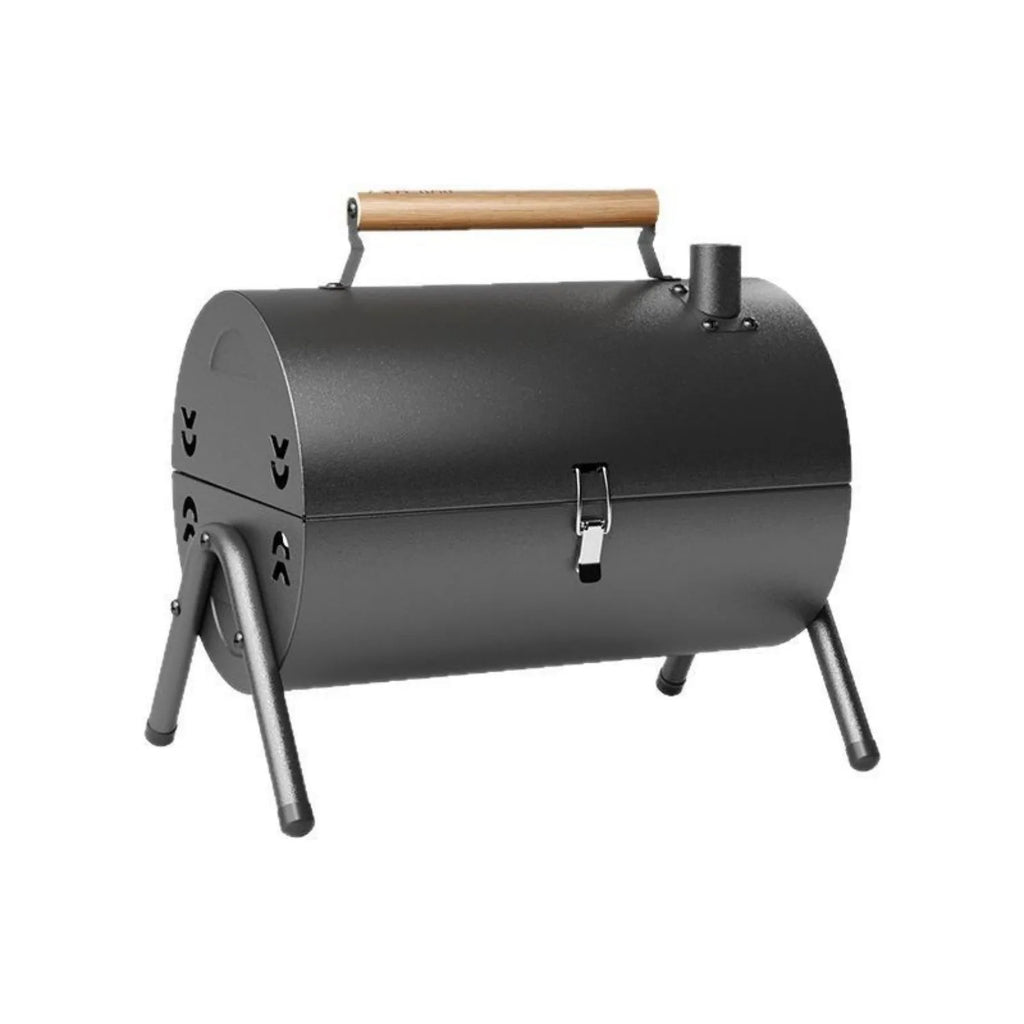 White portable charcoal barbecue grill with chimney oven, folded legs, two grill meshes, and detachable fuel tanks on a wooden table.