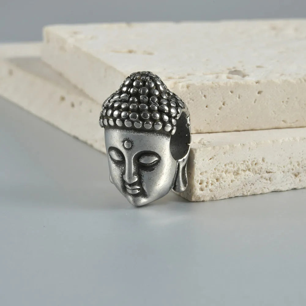 Stainless steel hollow skull Buddha head earrings for auricle piercing in hip hop style.