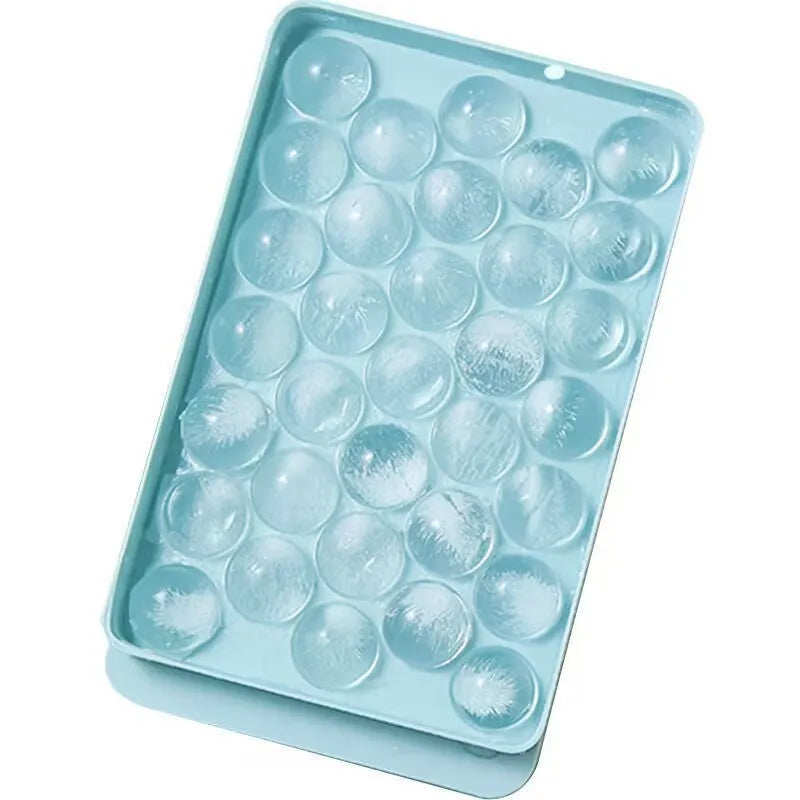 Blue flexible PE ice cube tray with lid, showing 33 round moulds, on a kitchen counter.