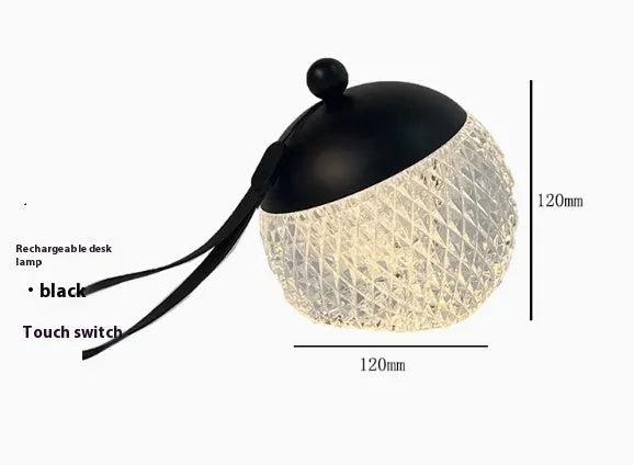 Portable cylindrical night lamp with touch control in metallic finish on wooden table