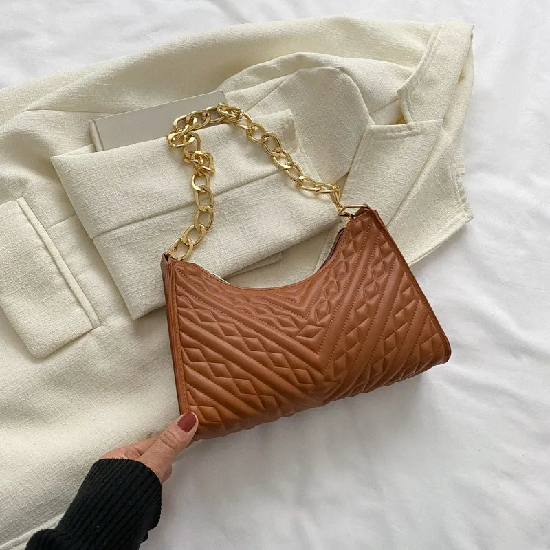 A structured black pleated women's shoulder bag with a chain strap and a soft handle, showing its square shape.