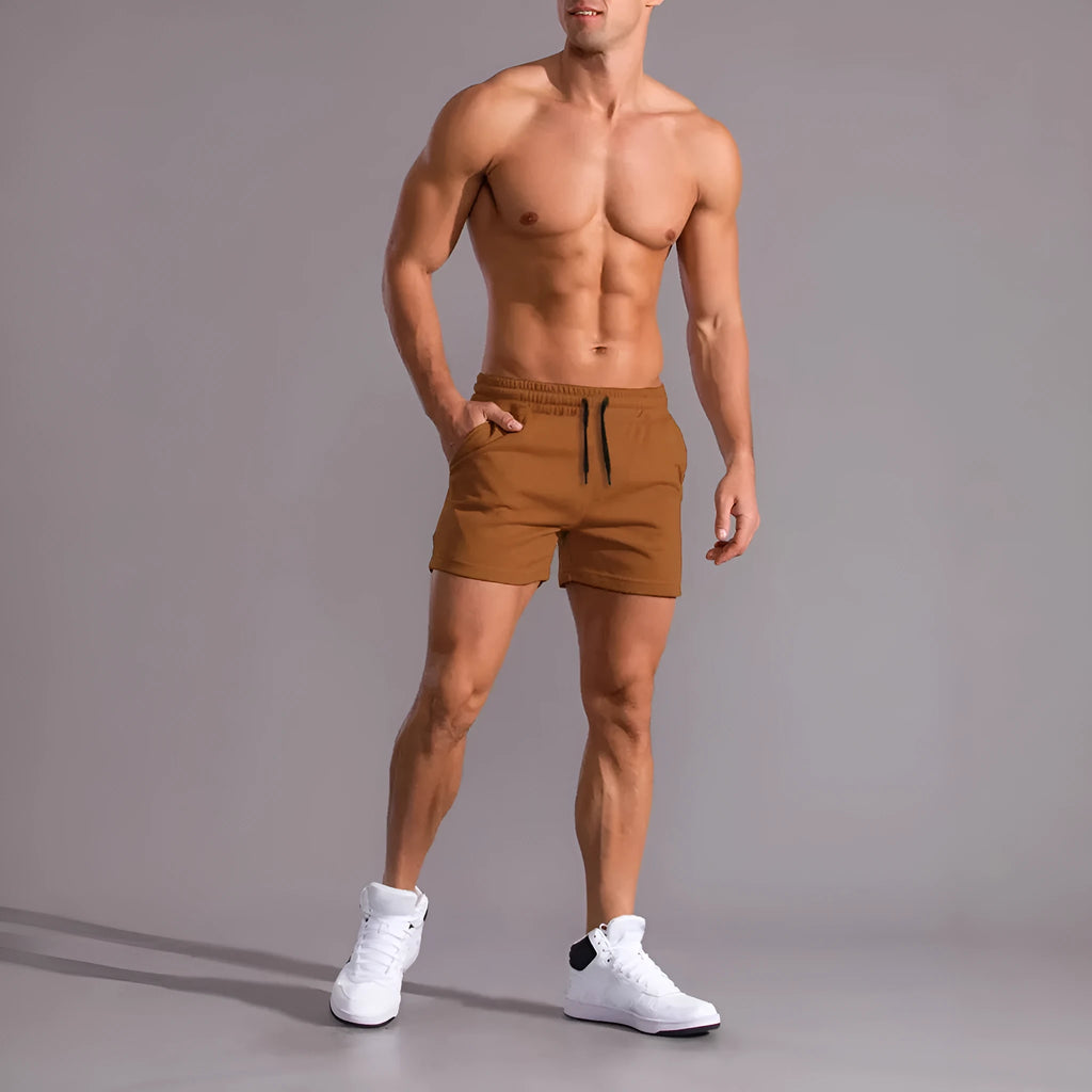 Three pairs of men's solid colour shorts with elastic drawstring waists in black, khaki and light brown