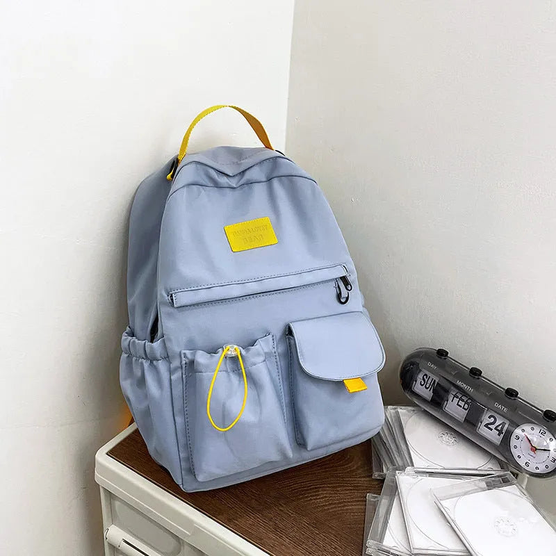 Nylon backpack school bag for junior high students, large capacity 20-35L, waterproof, with computer pocket, available in black.