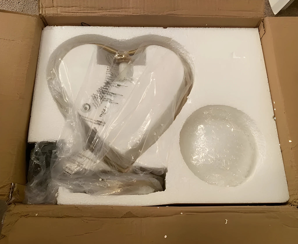 White heart shaped battery-operated LED lamp emitting a warm glow on a table.
