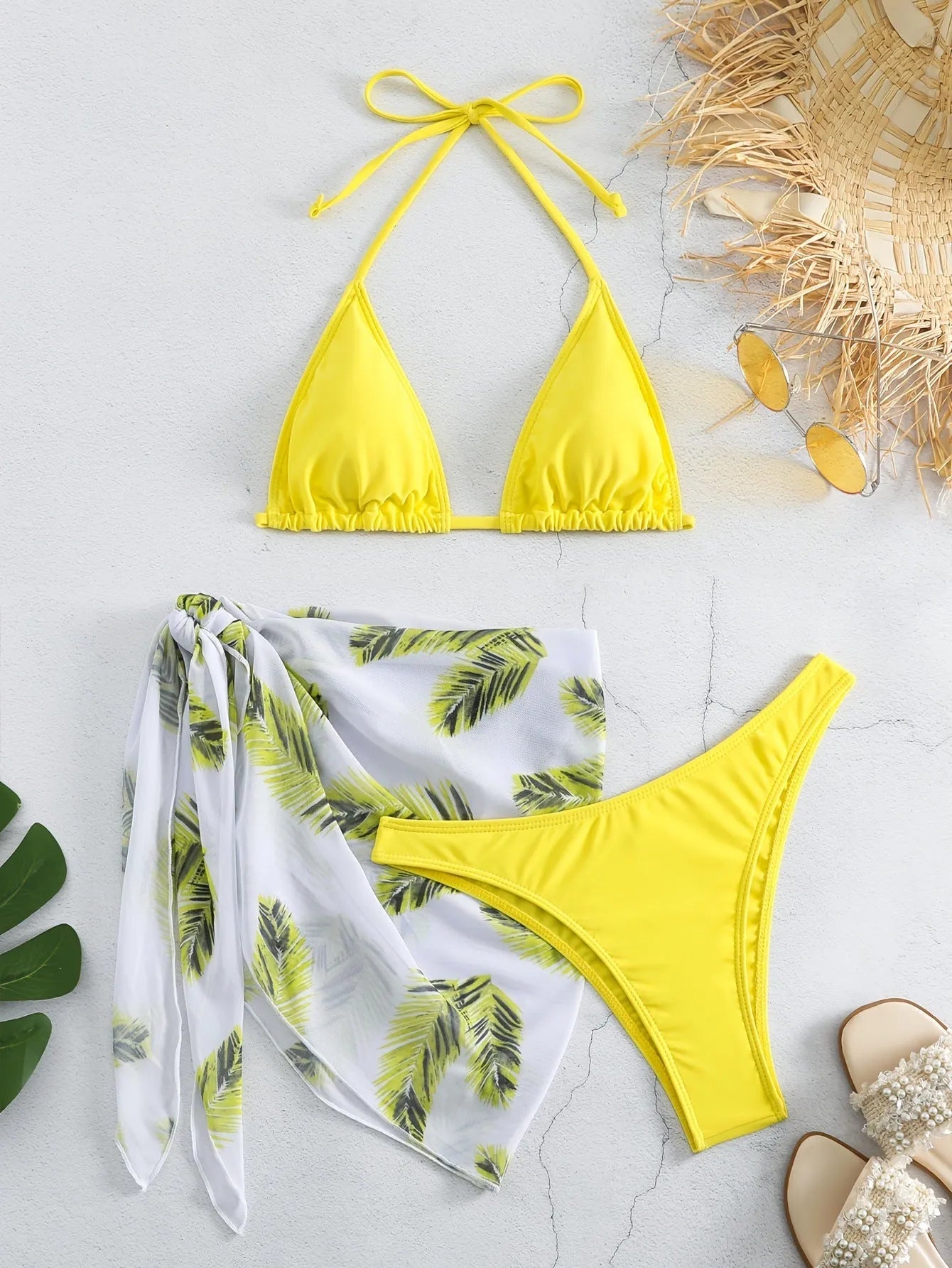 Women's orange polyester bikini set with a matching printed gauze skirt laid flat.
