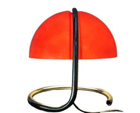 Retro metal mushroom table lamp with three-colour light in orange finish on a bedside table