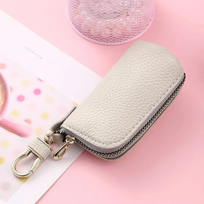 Black pu leather key case with silver zipper closure showing key ring inside