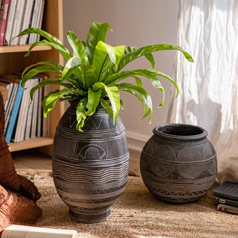 Medium cement flower pot with African ancient tank ethnic design and drainage hole.