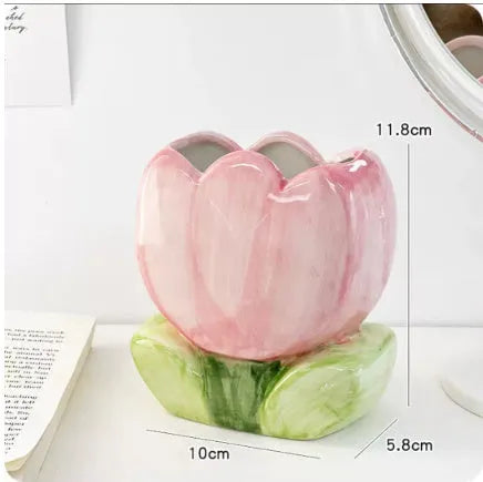 Ceramic floral pen holder box in pink tulip design on a desk.