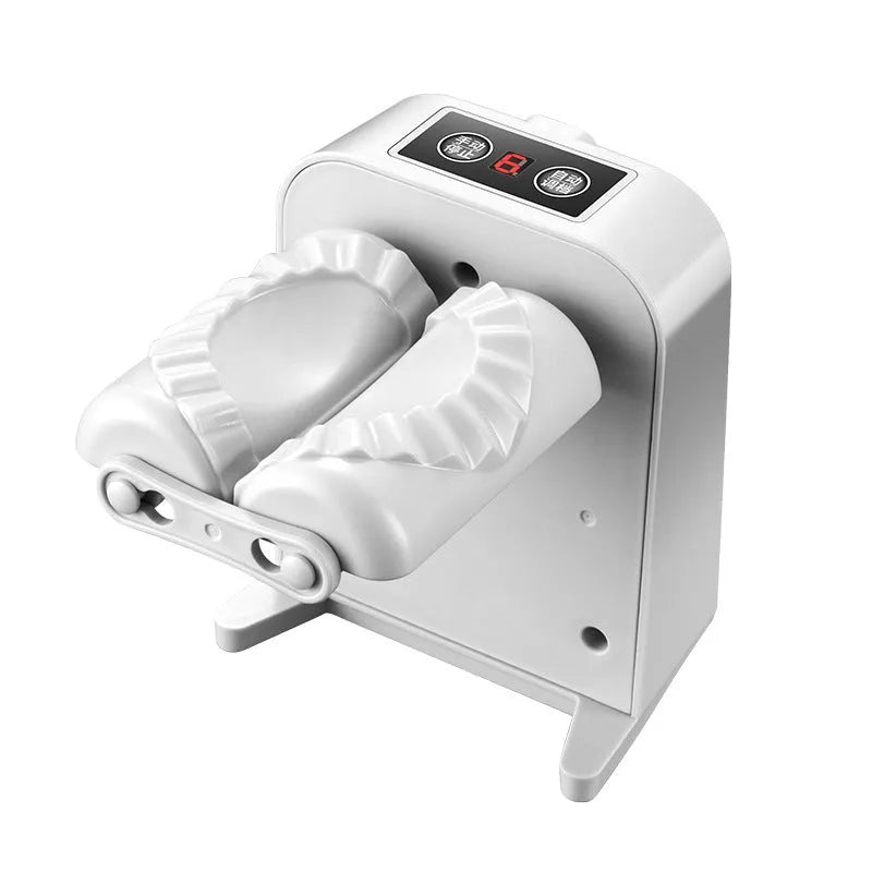 White automatic electric dumpling maker machine with USB cable, brush, and spoon on a kitchen counter.
