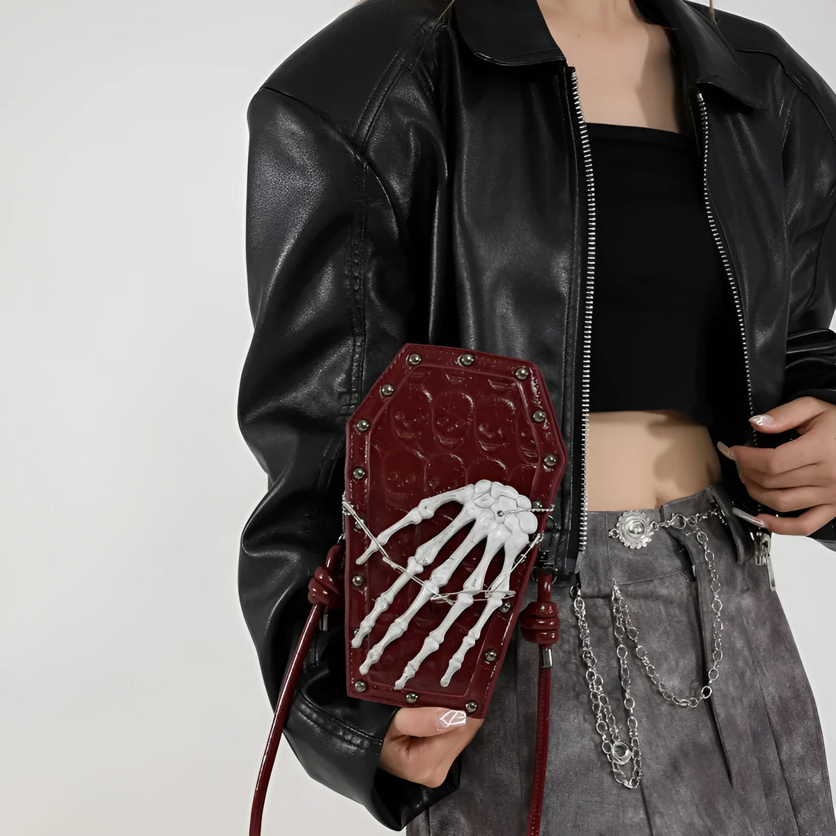 Square vertical one-shoulder handbag with single strap, embossed detail, and phone pocket