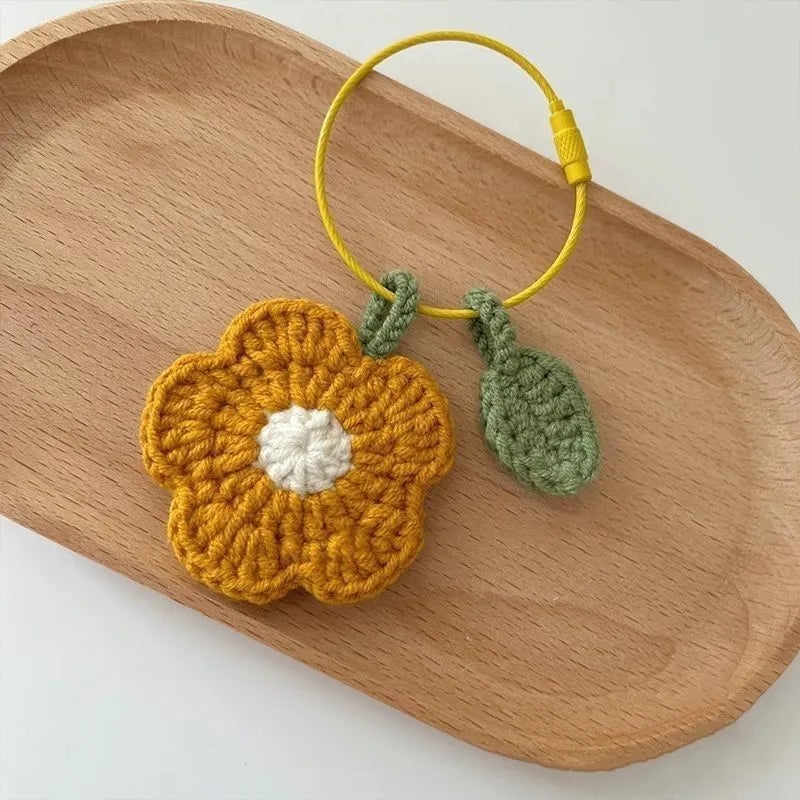Hand-crocheted wool pendant in small flower design, available in red or yellow colours
