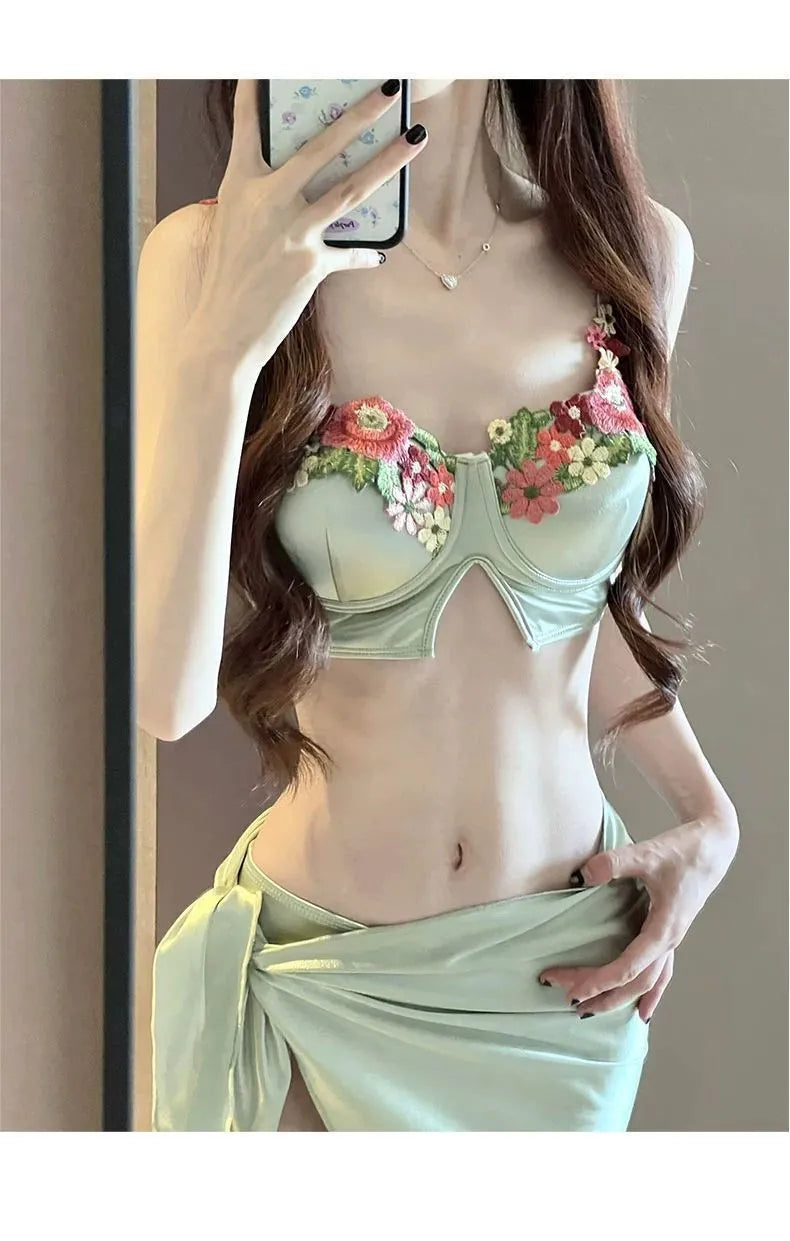 Green women's three-piece bikini set showing triangle top, briefs, and matching skirt on a white background.