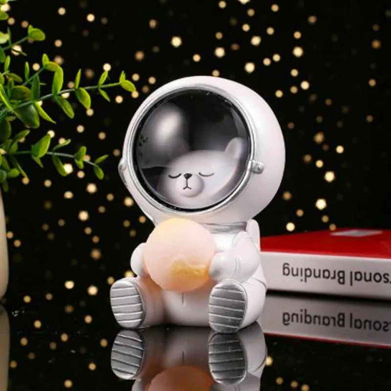 Resin bear-shaped starry sky night light with soft LED glow on a wooden table.