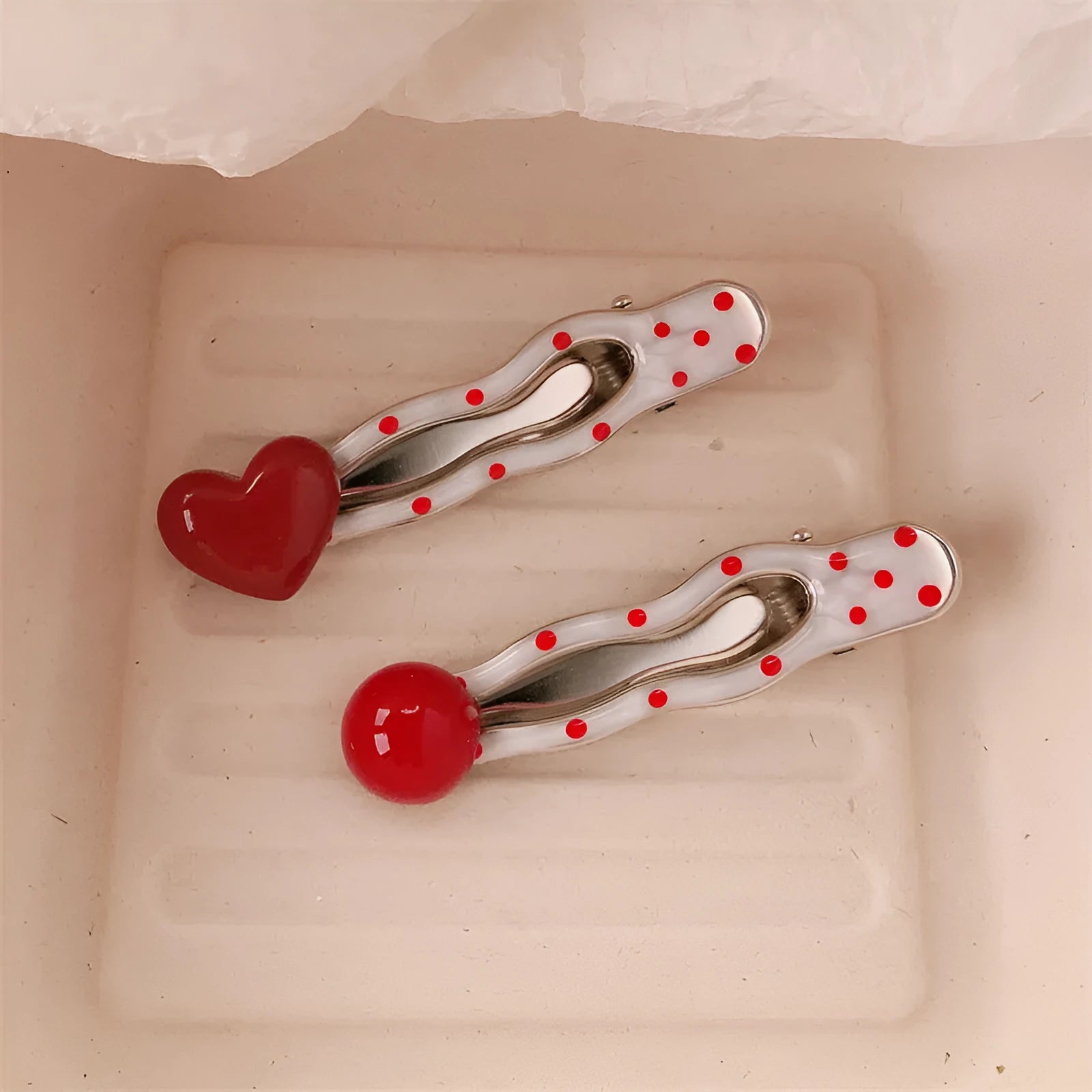 Red handmade hair clip shaped like a 3D love heart with vintage white dots, on a white background.