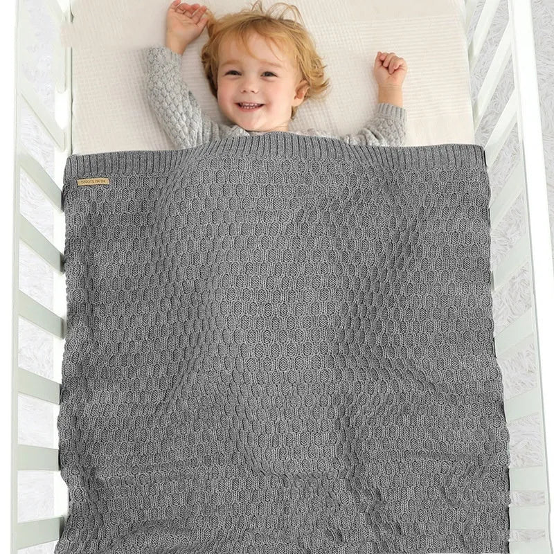 Solid colour baby blanket with raised 3D line texture, shown in beige khaki colour, laid flat to show 70cm by 90cm size.