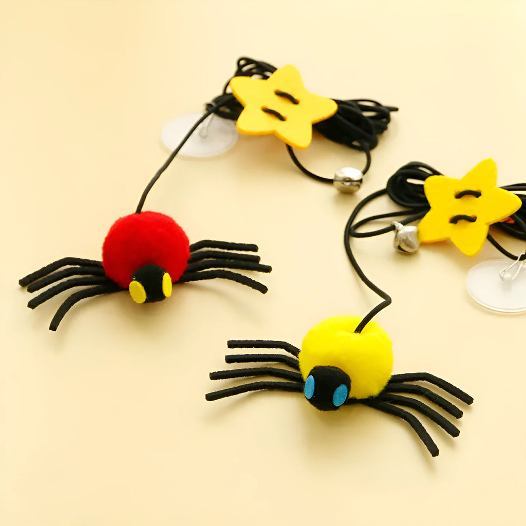 Red hanging cat toy with elastic rope, feathers, and bell spider ornament mounted on door