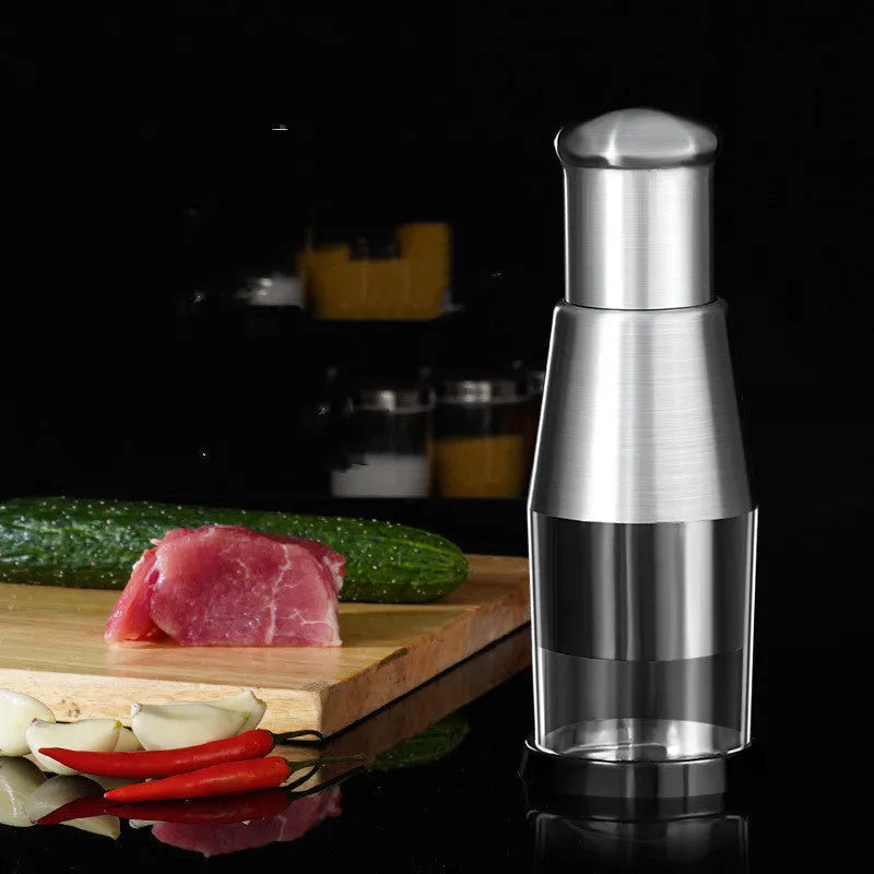 Manual garlic crusher and onion chopper in black with stainless steel blades on a kitchen counter